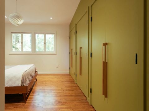 Greenville bedroom with lime green floor-to-ceiling wardrobes, vertical wooden pull handles, hardwood flooring, and large windows by Tekton Builds.